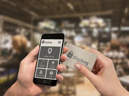 First-person view: A person using the 'Digibag' app and NFC card at a trade fair.